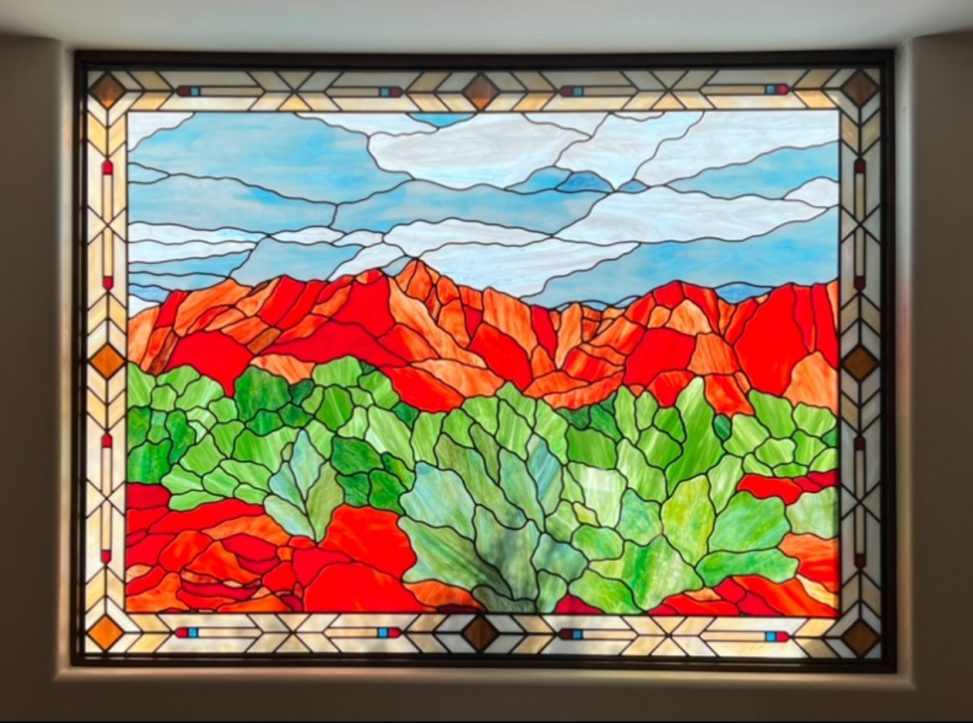 Landscape in Kayenta, UT, with rocks, desert plants, Southern Utah mountains, and blue sky